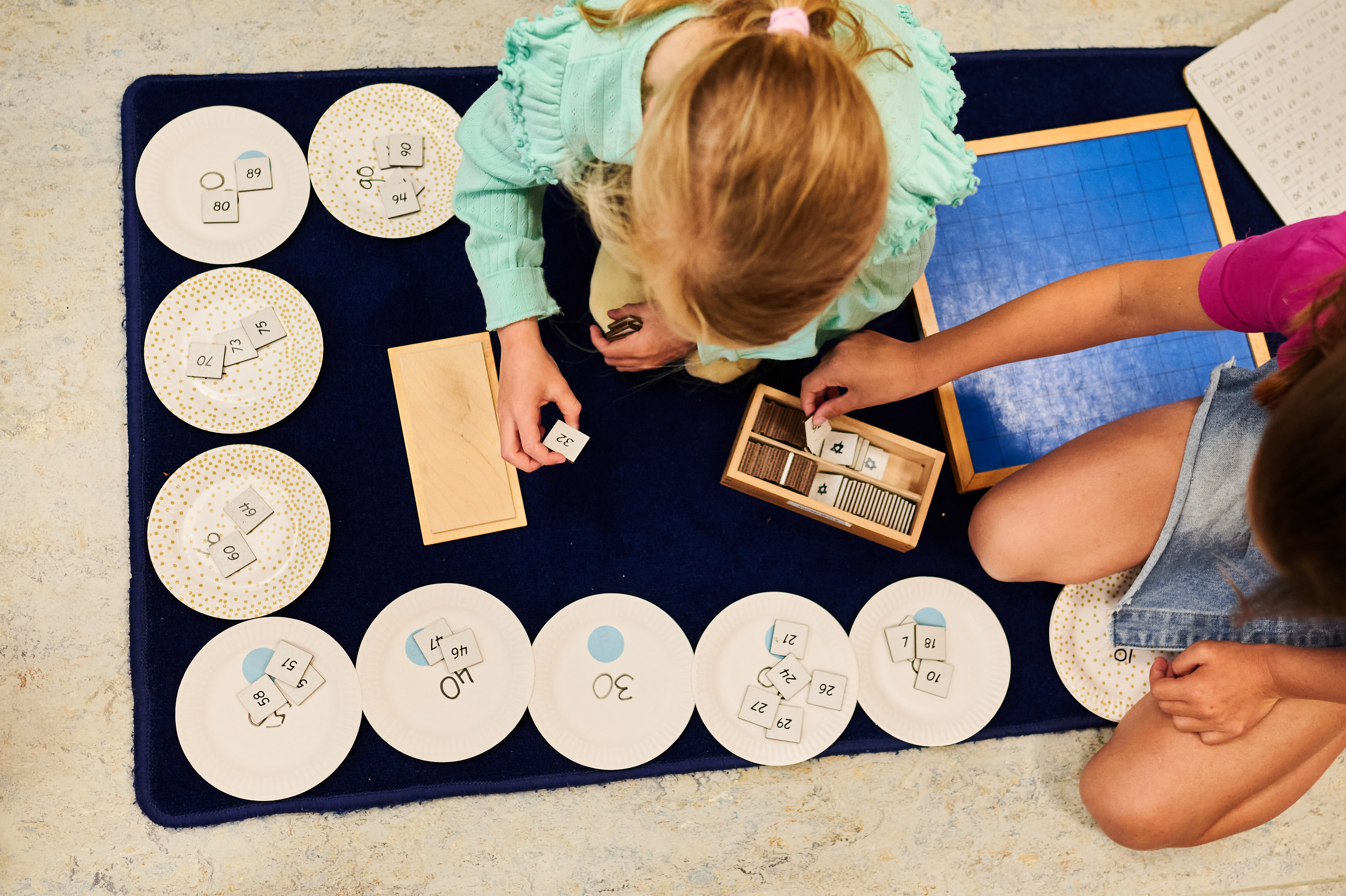 Twee leerlingen sorteren cijferkaartjes op bordjes.