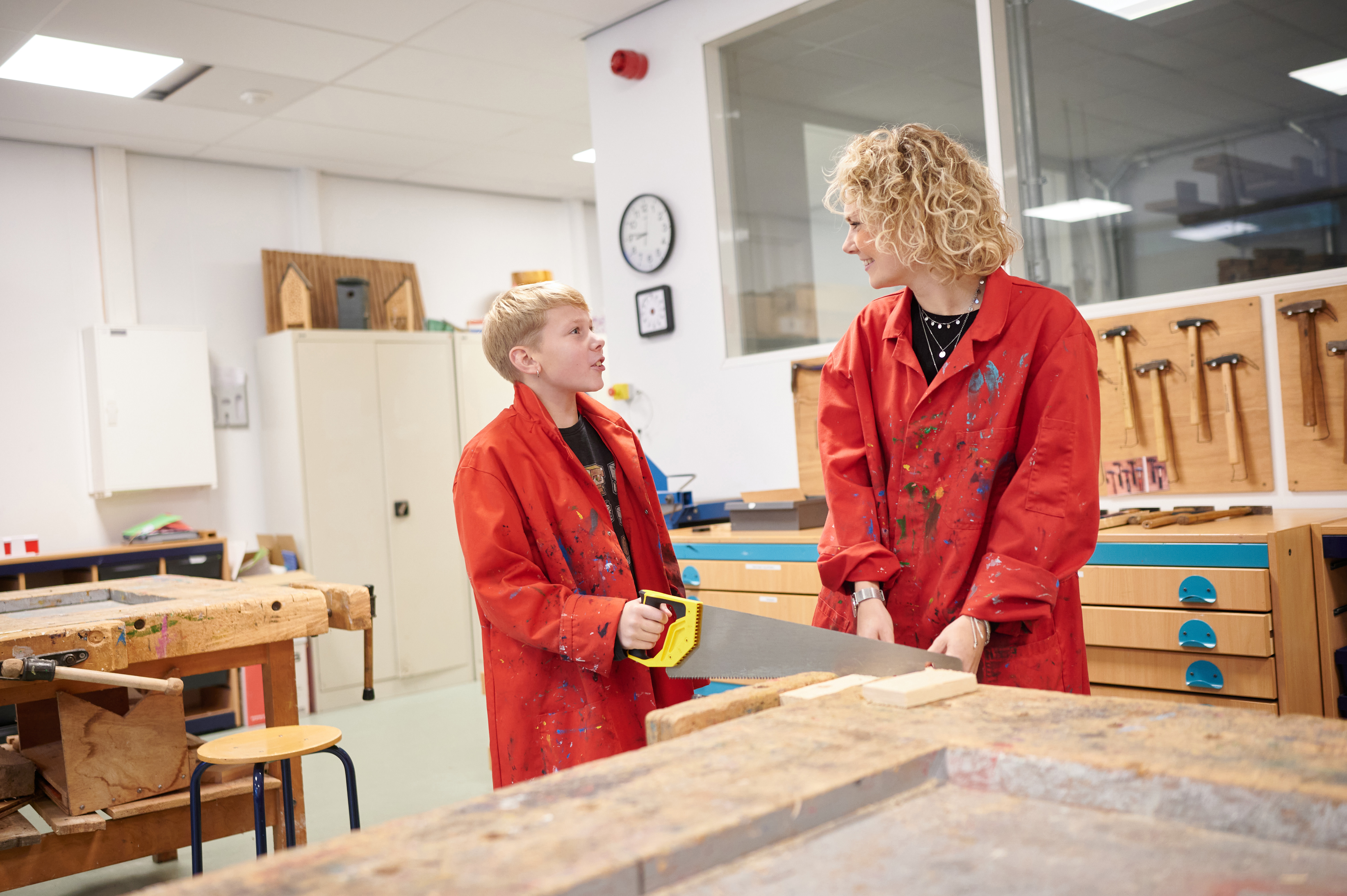 VSO-leerling en docent werken met zaag in het technieklokaal.