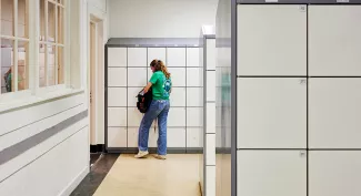 Vo-leerling bij kluisjes in kluisjeshuis Stadslyceum.