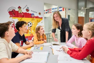 Groepje leerlingen in gesprek met de docent.