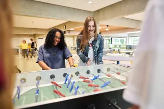 Leerlingen spelen tafelvoetbal.